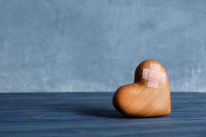 A wooden heart with a bandage on it.