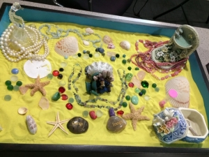 A sand tray decorated with shells and trinkets
