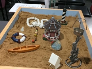 A sand tray decorated with beach items