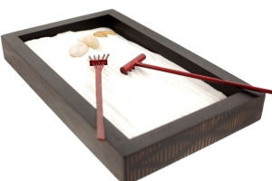 Image of a sand tray with some rocks and two rakes in it